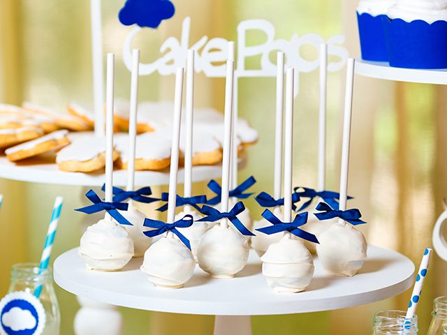 Candy bar on baby's christening party with a lot of different candies and beverages. Decorated in blue colors, clouds theme, indoor